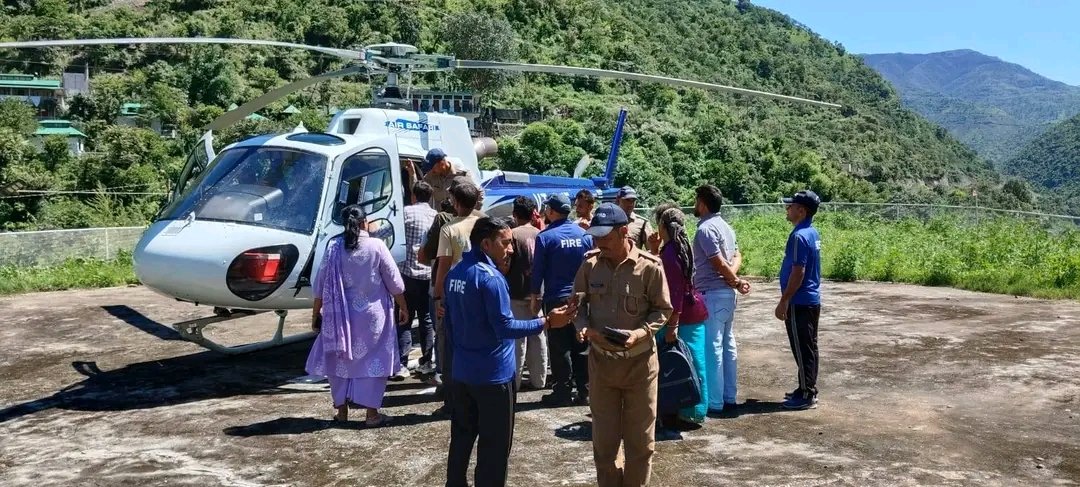 नौगांव चामी हेलीपैड से गर्भवती महिला को हेली एंबुलेंस से देहरादून भेजते स्वास्थ्यकर्मी